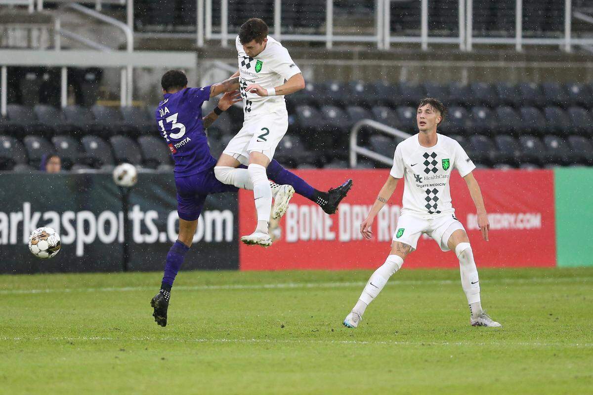 Lexington Sporting Club’s Tate Robertson (2) tried to win a ball against Louisville City’s Amadou Dia on Wednesday night. LSC plays its home opener Saturday night in Georgetown.