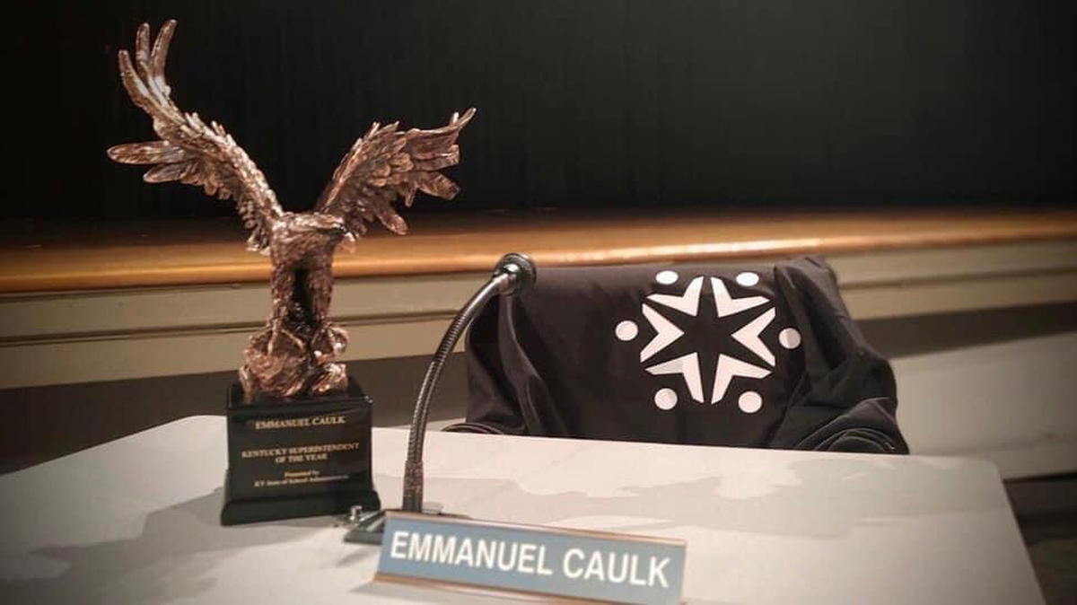 The late Fayette Superintendent’s Manny Caulk’s empty chair, his name plate, and his Kentucky Superintendent of Year award were included in a memorial following his death on Friday December 4. A search for his replacement is underway.