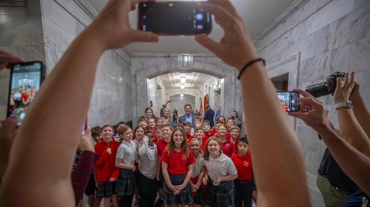 Kentucky Gov. Andy Beshear poses for a picture with fourth grade students from Louisville’s St. Margaret Mary School following a media conference at the Kentucky state Capitol in Frankfort, Ky., on Wednesday, Nov. 8, 2023, a day after Beshear won reelection.