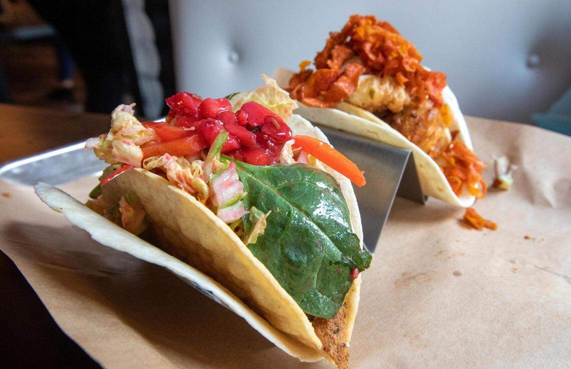 Agave & Rye’s Hot Summer Dream taco, left, features herbed chicken, brie fondue, cabbage and baby spinach, raspberry vinaigrette, strawberry relish and pine nuts. The Bang Bang taco, right, features crispy cauliflower, corn fritters, queso, spicy crispy carrots.