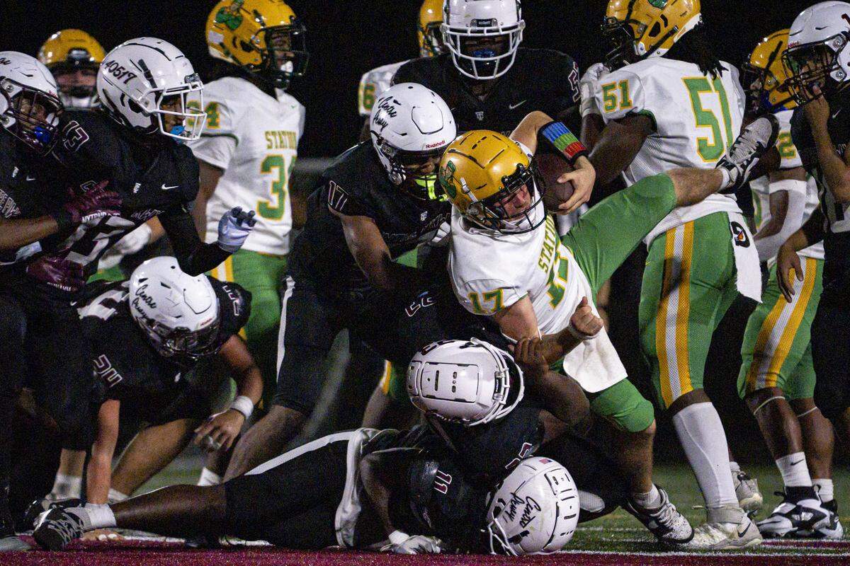 Tates Creek players tackle Bryan Station quarterback Coleson Carpenter during the Bryan Station football game against Tates Creek on Friday, Sept. 19, 2025, at Tates Creek High School in Lexington, Ky. Bryan Station won 35-14.