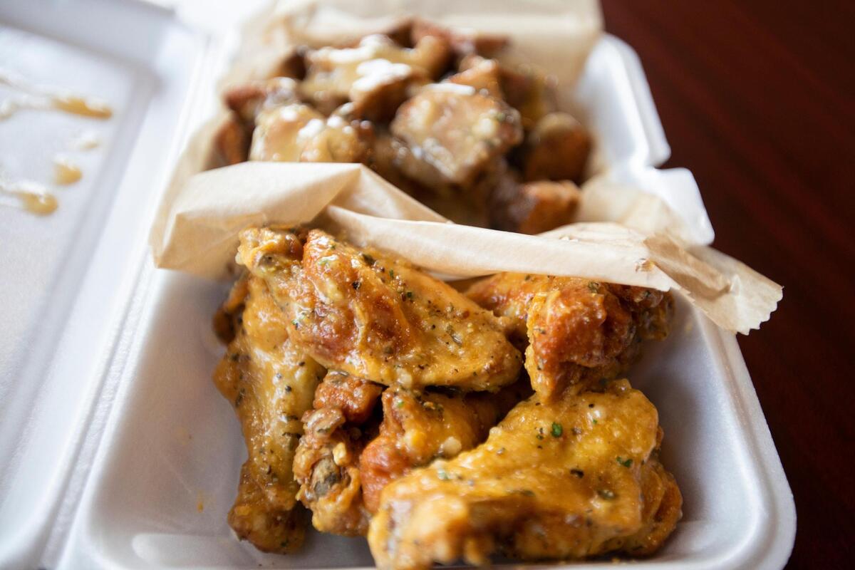 Eazy’s World flavored wings and potato slices with sauce from Thomas Williams at Wing KYng in Greyline Station in Lexington, Ky., Thursday, May 11, 2023.