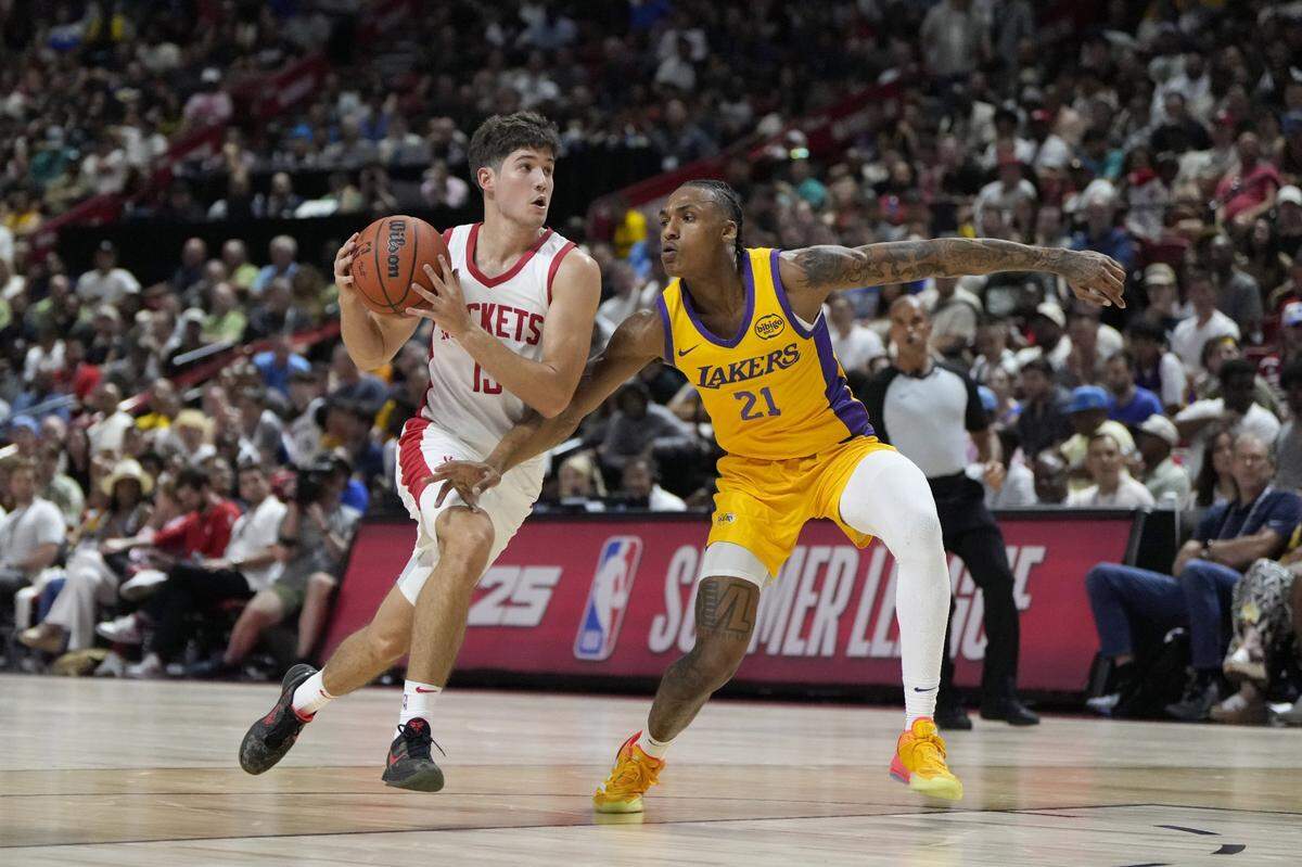 Reed Sheppard (15) drives against Lakers forward Maxwell Lewis. Sheppard, mostly playing the point for Houston, finished with four turnovers in almost 30 minutes of action in his pro debut.