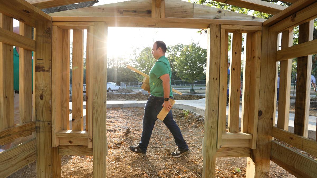 Volunteers help build a new playground at Shillito Park off of Reynolds Road on Wednesday, Sept. 18.