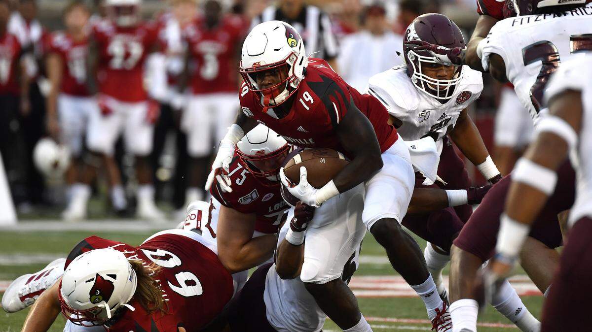 Louisville running back Hassan Hall (19) breaks through a hole in the Eastern Kentucky defensive line on Saturday night.