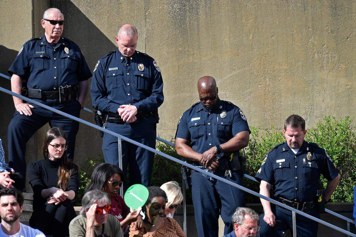 Officers with the Louisville Metro Police Department participate in a moment of silence during a vigil for the victims of Monday’s shooting at the Old National Bank in Louisville, Ky., Wednesday, April 12, 2023. (AP Photo/Timothy D. Easley)