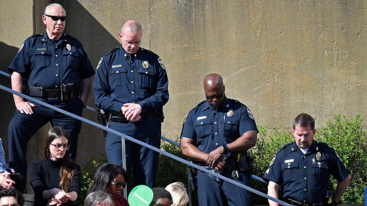 Officers with the Louisville Metro Police Department participate in a moment of silence during a vigil for the victims of Monday’s shooting at the Old National Bank in Louisville, Ky., Wednesday, April 12, 2023. (AP Photo/Timothy D. Easley)