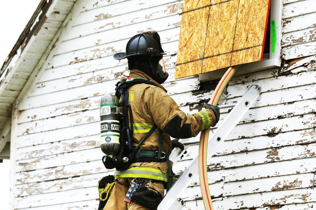 A Lexington Fire Department cadet feeds a water nozzle to fellow trainees inside a live burning structure during the Lexington Fire Recruit Class 73 “House Burn” on November 14, 2024, in Lexington, Ky.