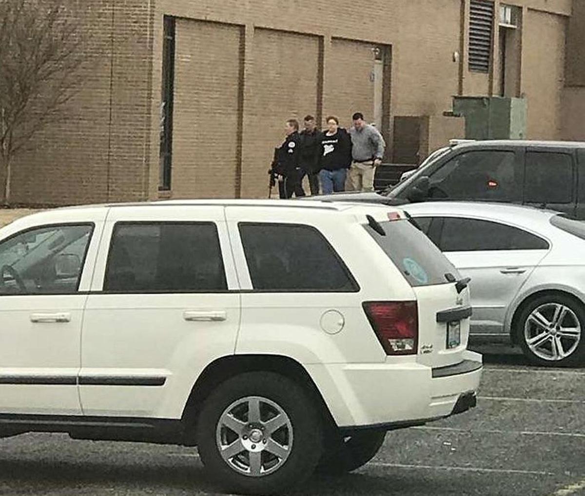 Police escorted a person out of Marshall County High School after a shooting Tuesday in Benton. Gov. Matt Bevin said two people were killed and several others were injured.