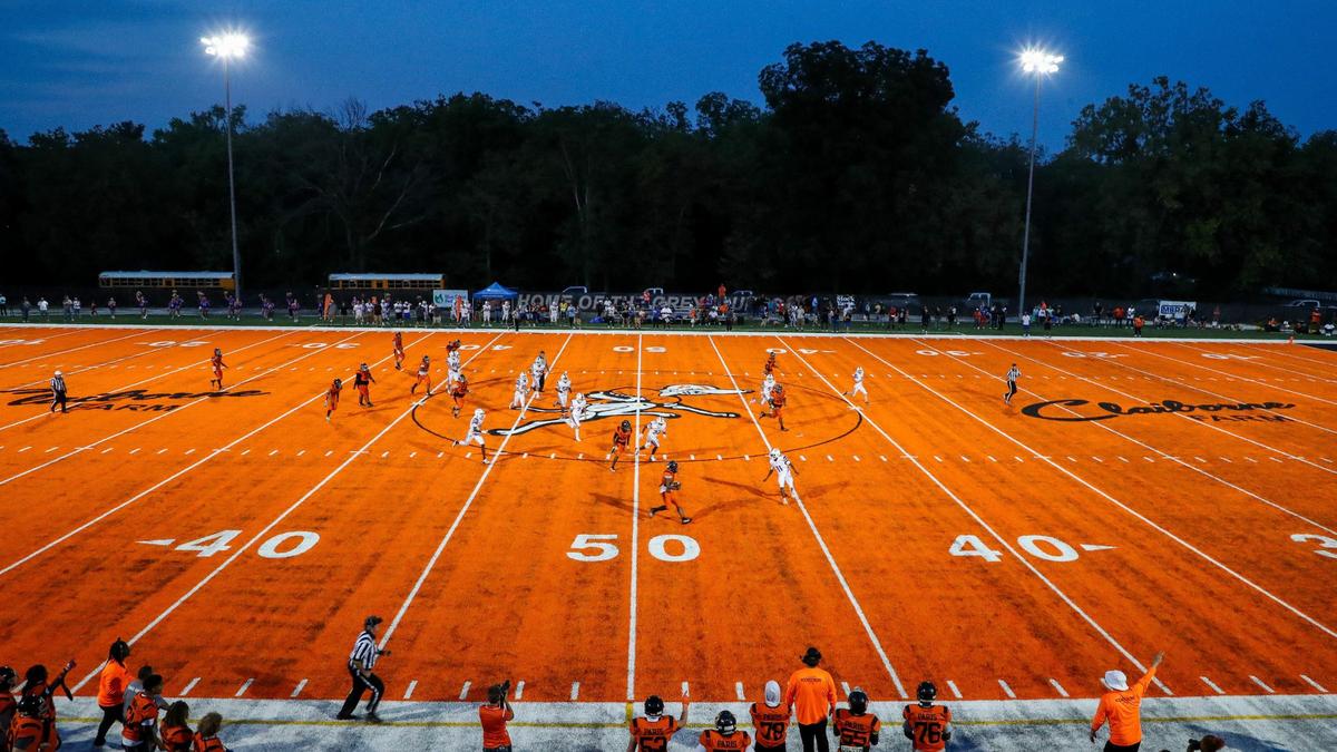 Paris’s Brandon Smith-Santiago runs downfield past the 50-yard-line under the lights on the Greyhounds’ bright, new orange football field during their game against Frankfort on Friday at Blanton Collier Stadium.