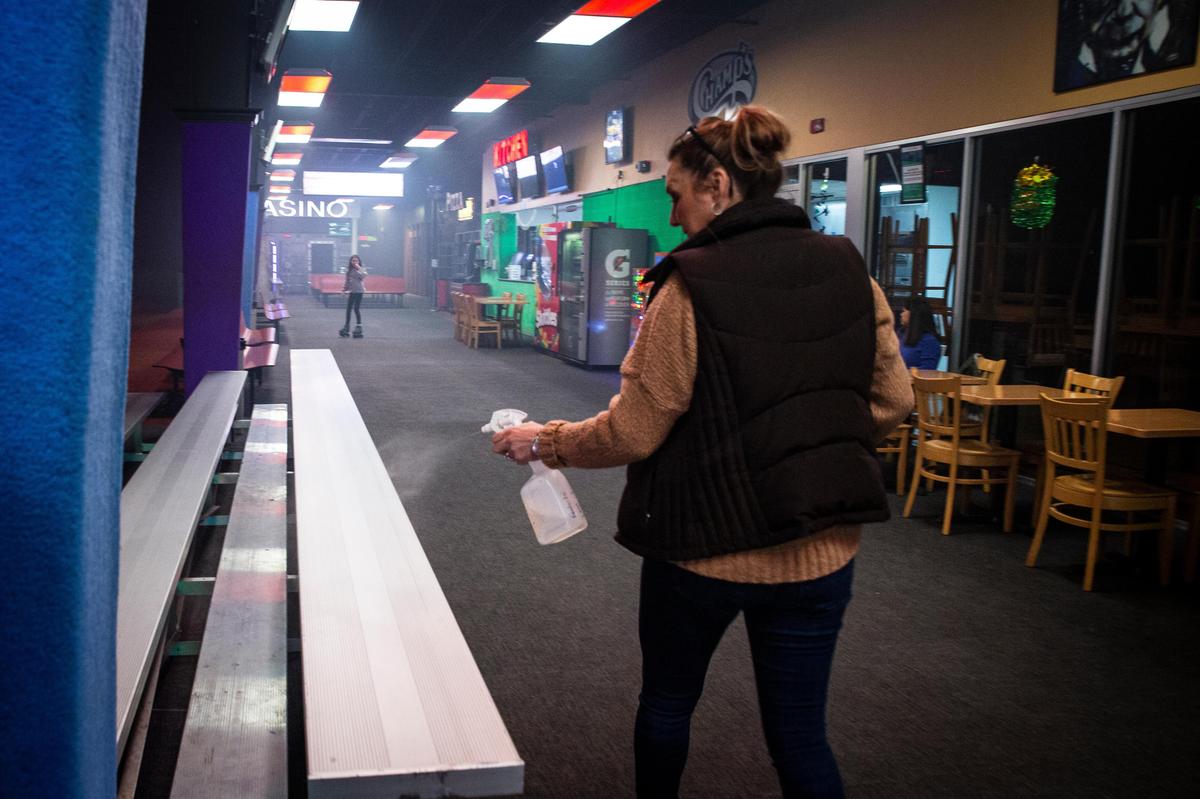 Tina Champa, owner of Champ’s, sprays down the facility with isopropyl alcohol in Lexington, Ky., on Monday, March 16, 2018. Nick Champa said Champ’s will remain open unless Governor Beshear or Mayor Gorton say otherwise.