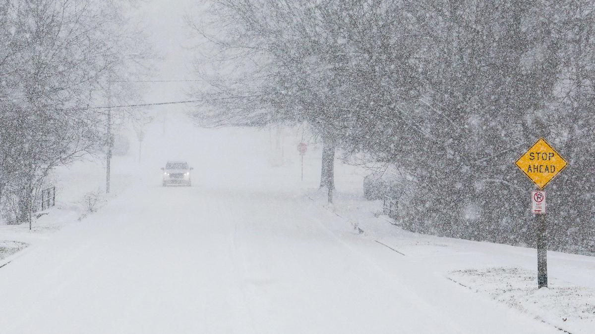 A car makes its way down Gainesway Drive during a winter snowstorm, Sunday Jan. 5, 2025 in Lexington, Ky.