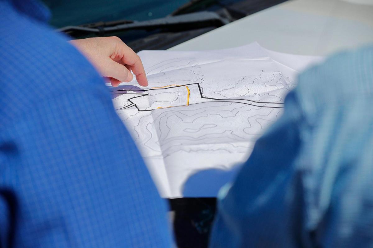 Nate Sandvig, left, and Michael Gambrel look at a map of an area in Bell County, Ky., where Sandvig’s company is seeking to develop a hydropower storage pump project. Water would be released from an upper reservoir and turn hydroelectric turbines, generating electricity, on its way to a lower reservoir, where it’d then be pumped to the upper reservoir again to repeat the journey. Tuesday, March 1, 2022