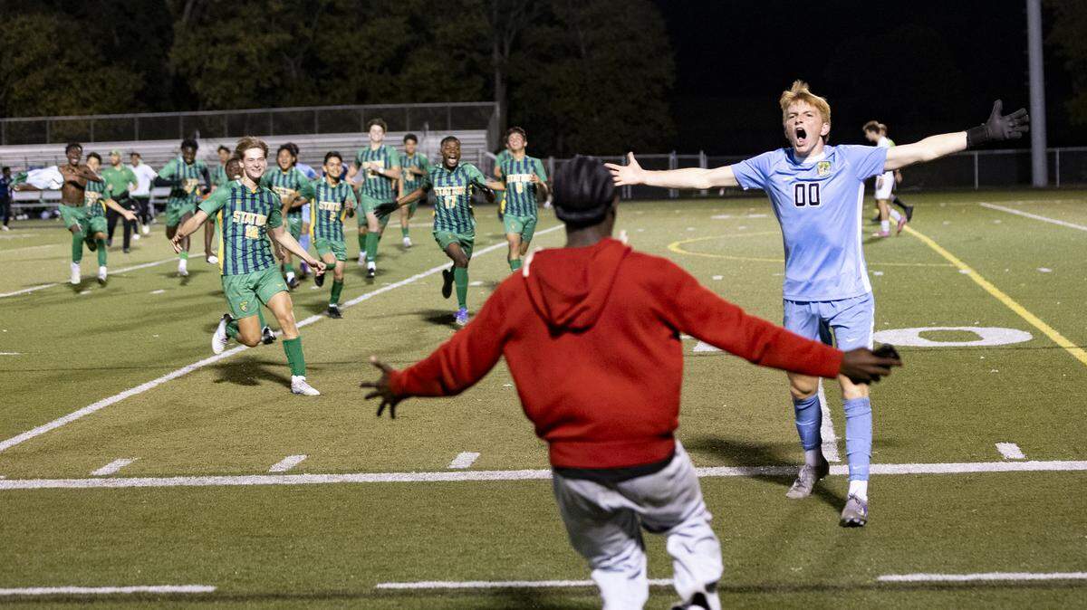 Bryan Station’s Luke Majors (00) celebrated the Defenders’ overtime penalty kick shootout win over Henry Clay as his teammates and student section closed in to join him after the 11th Region boys soccer championship game at Paul Laurence Dunbar High School on Friday.