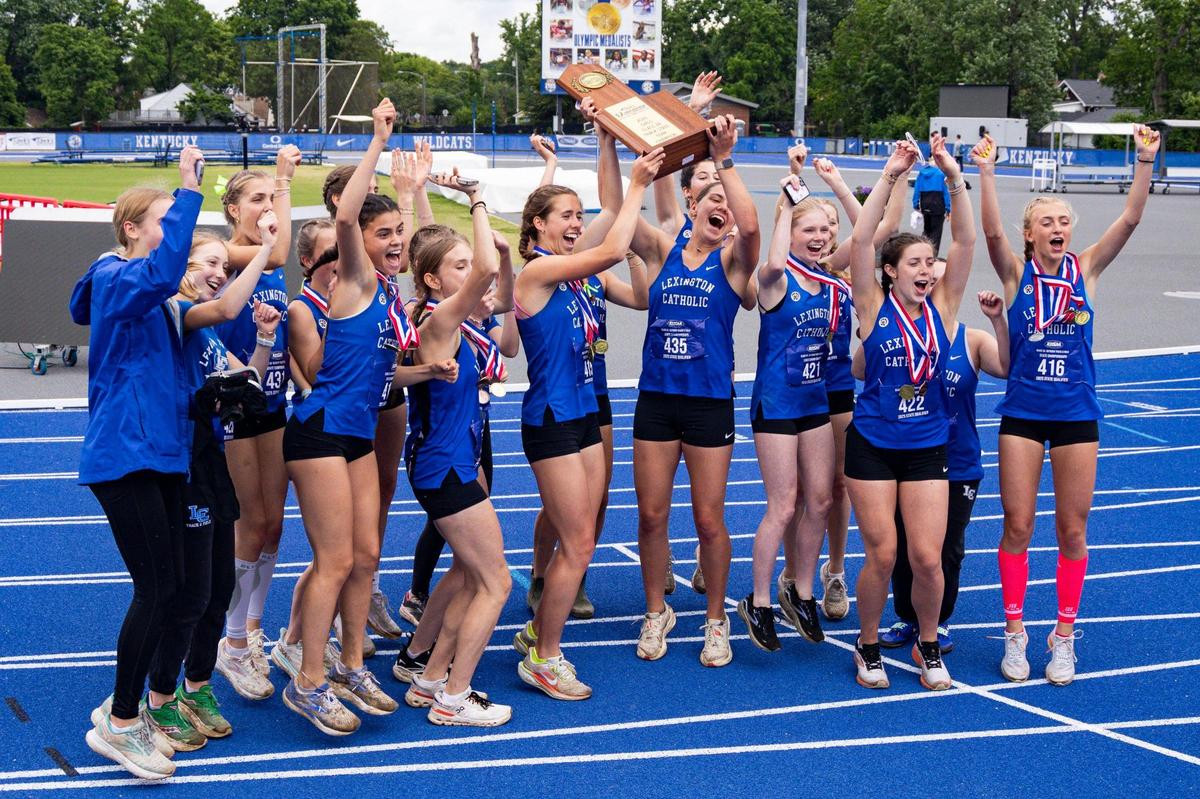 Lexington Catholic’s girls track team celebrates with their fans after winning the Class 2A track and field state championship on Friday.