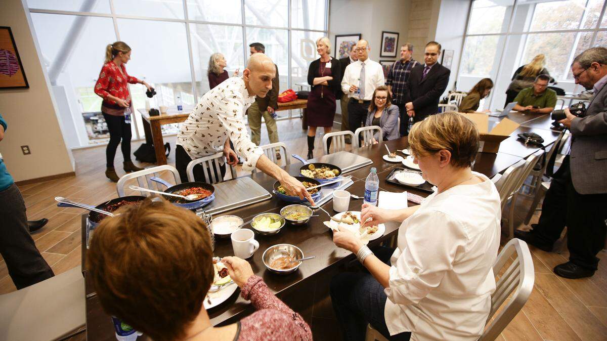 Chef Jehangir Mehta talked with Gina Mullin, left, and Jen Cooper about the meal he created in the Iron Chef-type competition with chef Fred Morin at the first International Society of Neurogastronomy at the University of Kentucky on Saturday.