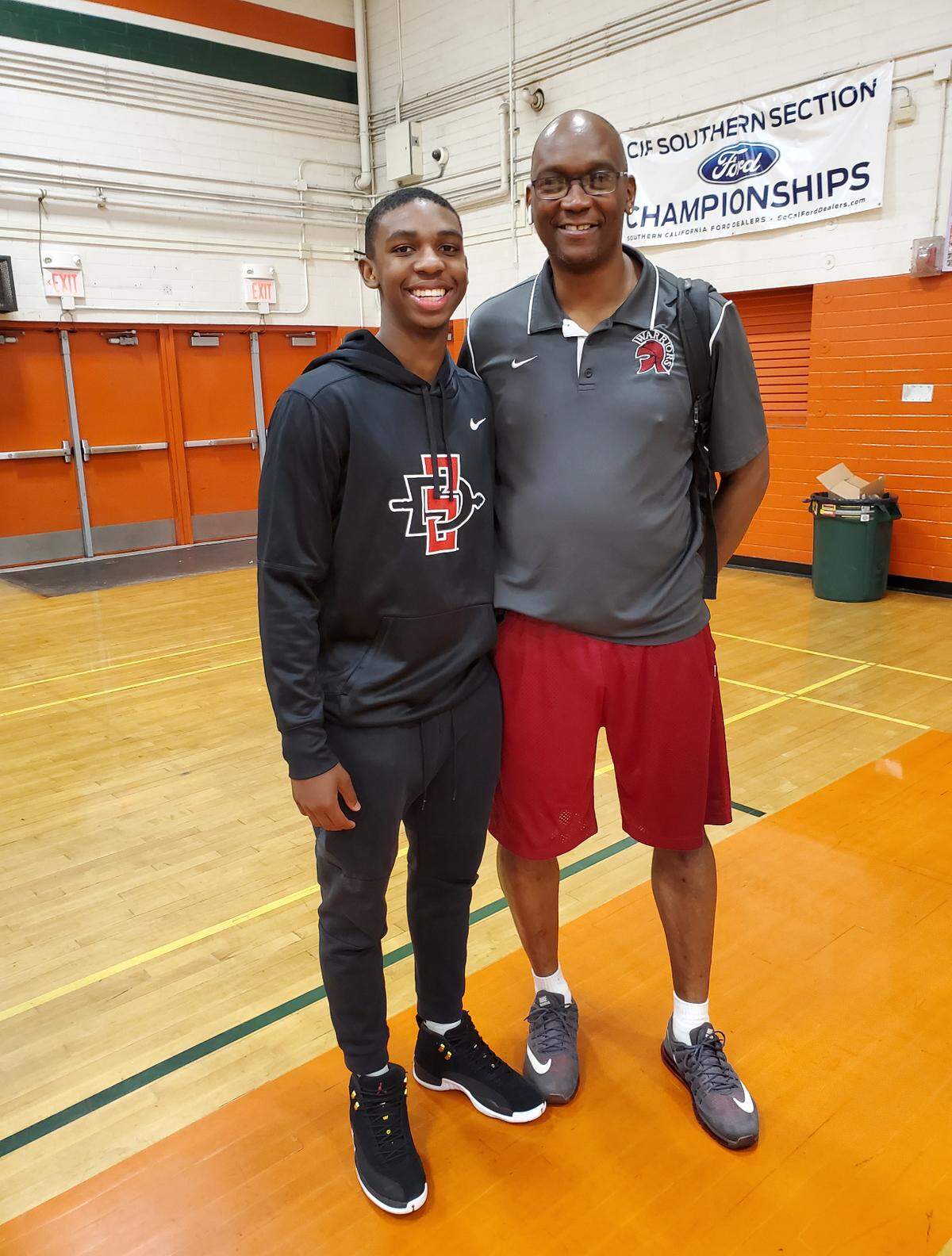 Lamont Butler, left, and his basketball mentor, Andre Spencer, at the player’s signing day ceremony in high school, before attending San Diego State. Spencer died three months before Butler played his first college game.