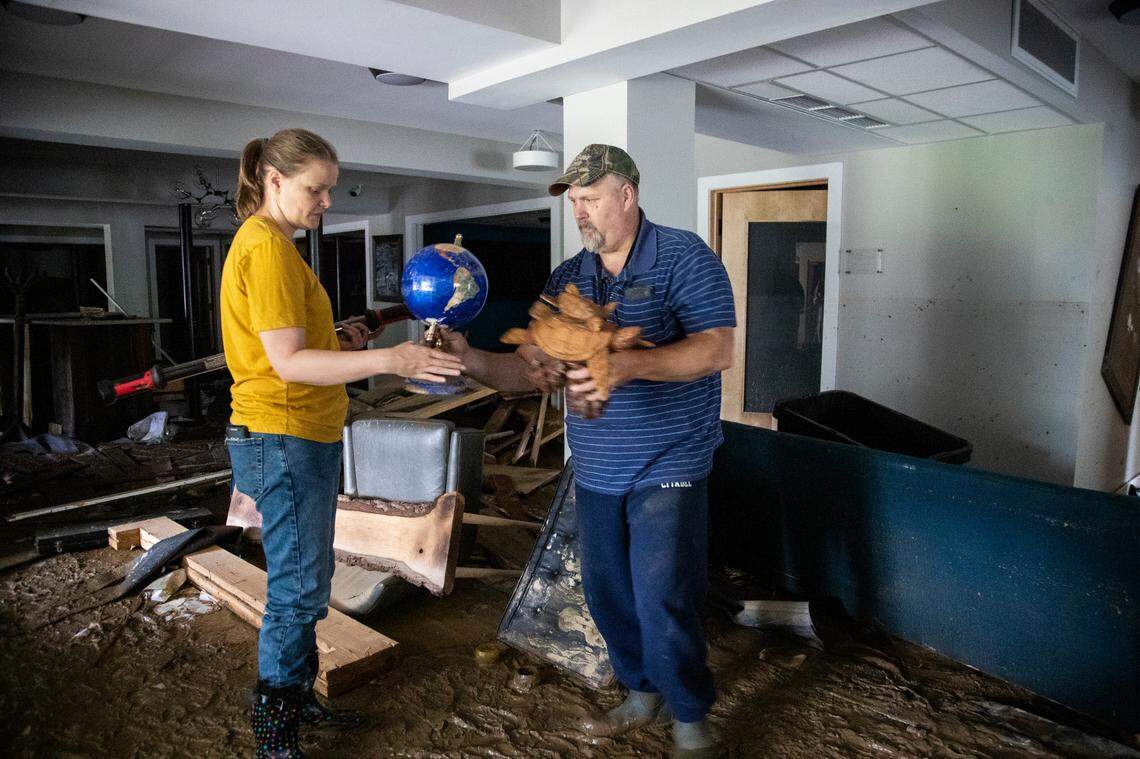 Melissa Helton and her husband Keith Helton salvage objects from her office at the Hindman Settlement School after historic flooding damaged the entire first floor in the building in Hindman, Ky., Saturday, July 30, 2022.