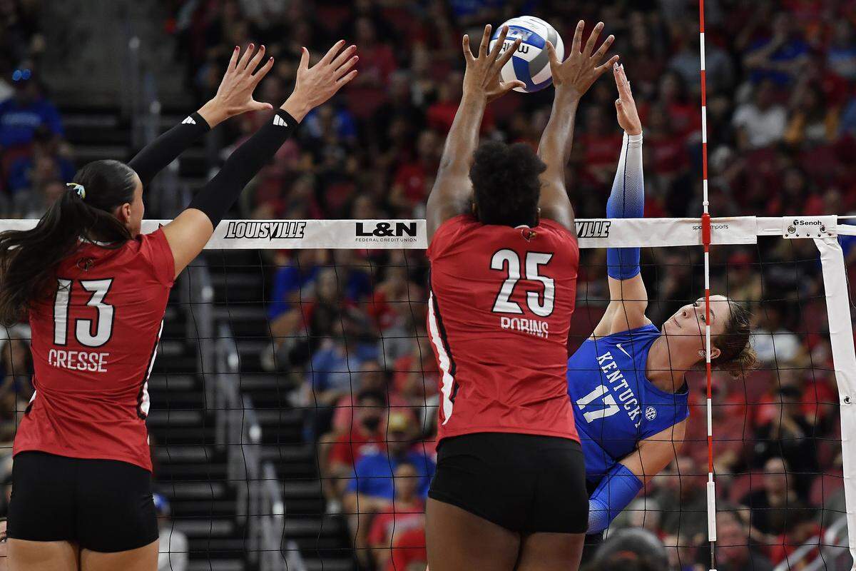 Kentucky outside hitter Brooklyn DeLeye (17) attempts a kill past the defense of Louisville middle blocker Cara Cresse (13) and middle blocker Reese Robins (25) during UK’s win over the Cardinals on Thursday.