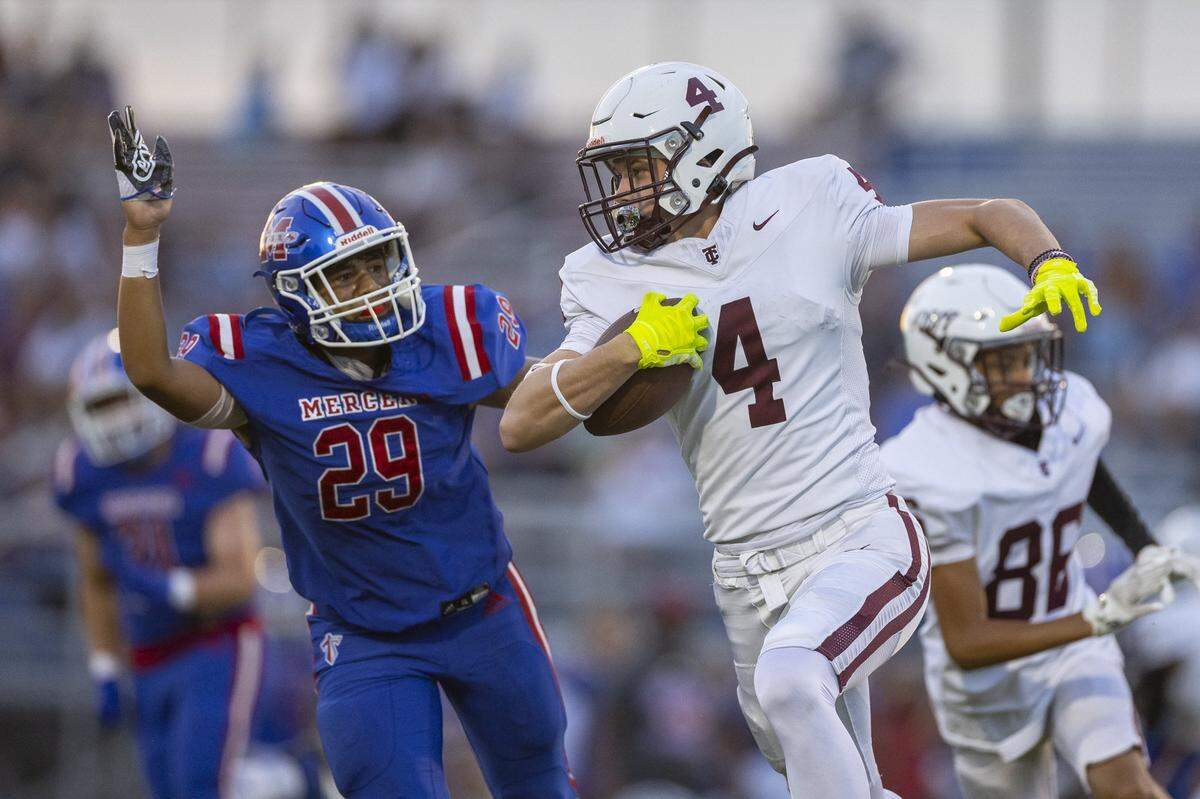 Tates Creek's JT Cooper (4) runs past Mercer County's Brennen Taylor (29) during the Fort Harrod Bowl at Alvis Johnson Field in Harrodsburg, Ky., on Saturday, Aug. 23, 2025.