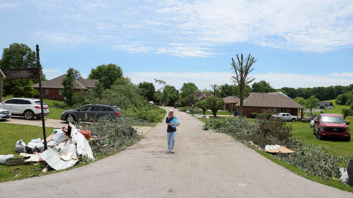 Hannah Robbins from Faith Assembly of God Church in London brings water to storm survivors on Pine Oak Trail in the Crooked Creek neighborhood east of London, Ky., Sunday, May 18, 2025. Two days earlier, thunderstorms and a deadly tornado ripped through the Laurel County, destroying many homes.