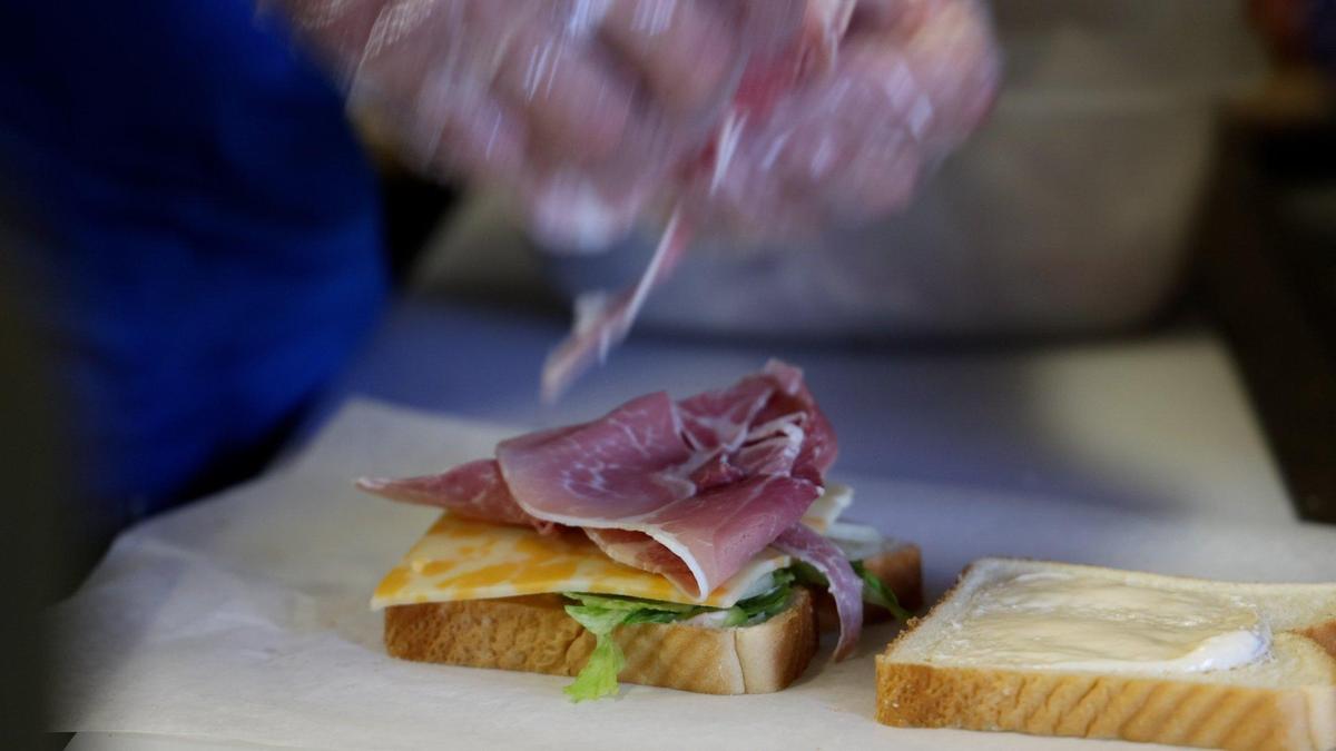 Jot ’em Down’s owner Robey Terrell makes a country ham sandwich for a customer on Wednesday, June 1, 2022, at what is Lexington’s oldest place to get sandwich, the store at Iron Works Pike and Russell Cave Road.