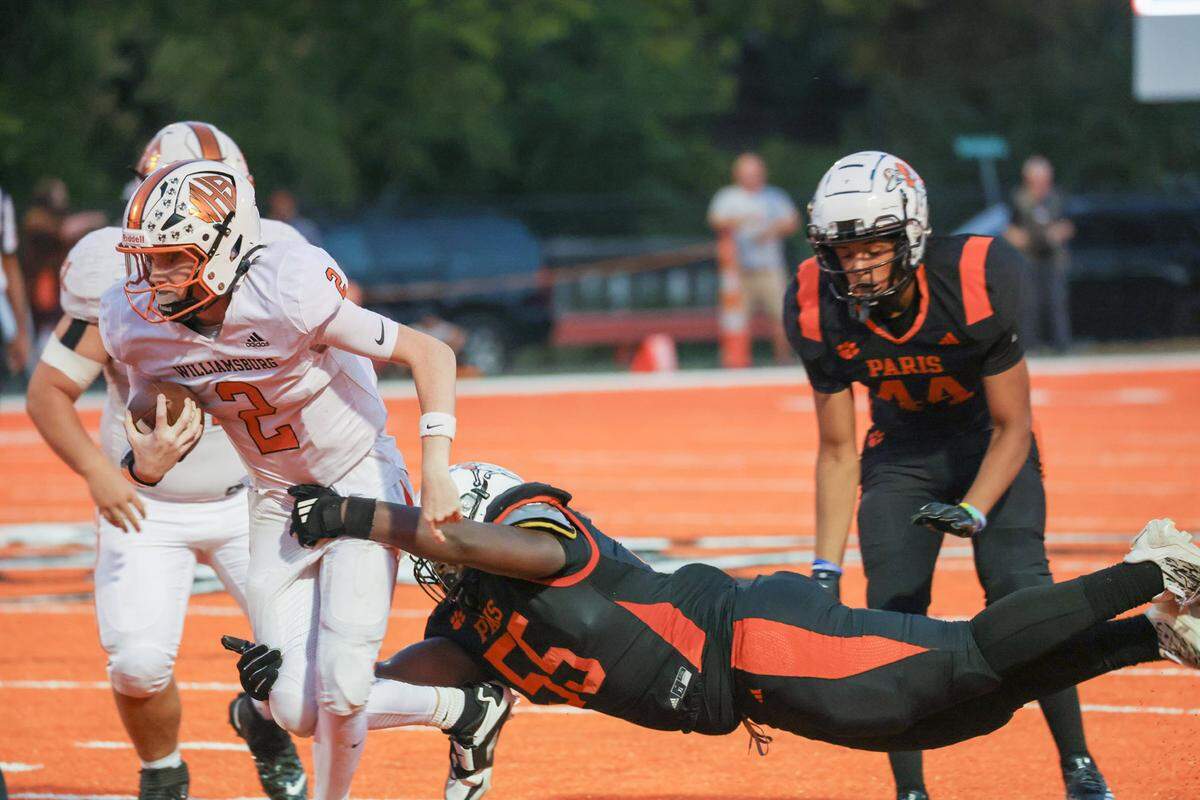 Williamsburg’s Reece Hatcher gains yardage with Paris’ Chase Williams in tow in the second quarter Friday night.
