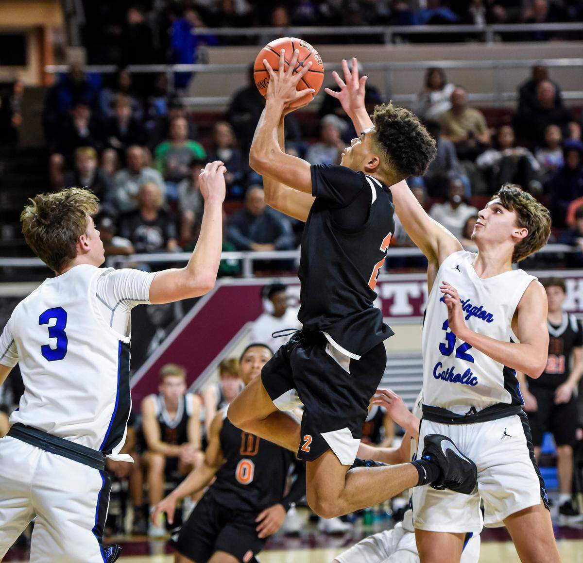 Jaylan Green of Frederick Douglass tried to get through Lexington Catholic’s Jack Gohmann, left, and Luke Wedding, right. Catholic’s switch from man-to-man defense to zone sealed off the Broncos’ repeated drives to the basket and changed the Knights’ fortunes Thursday night.