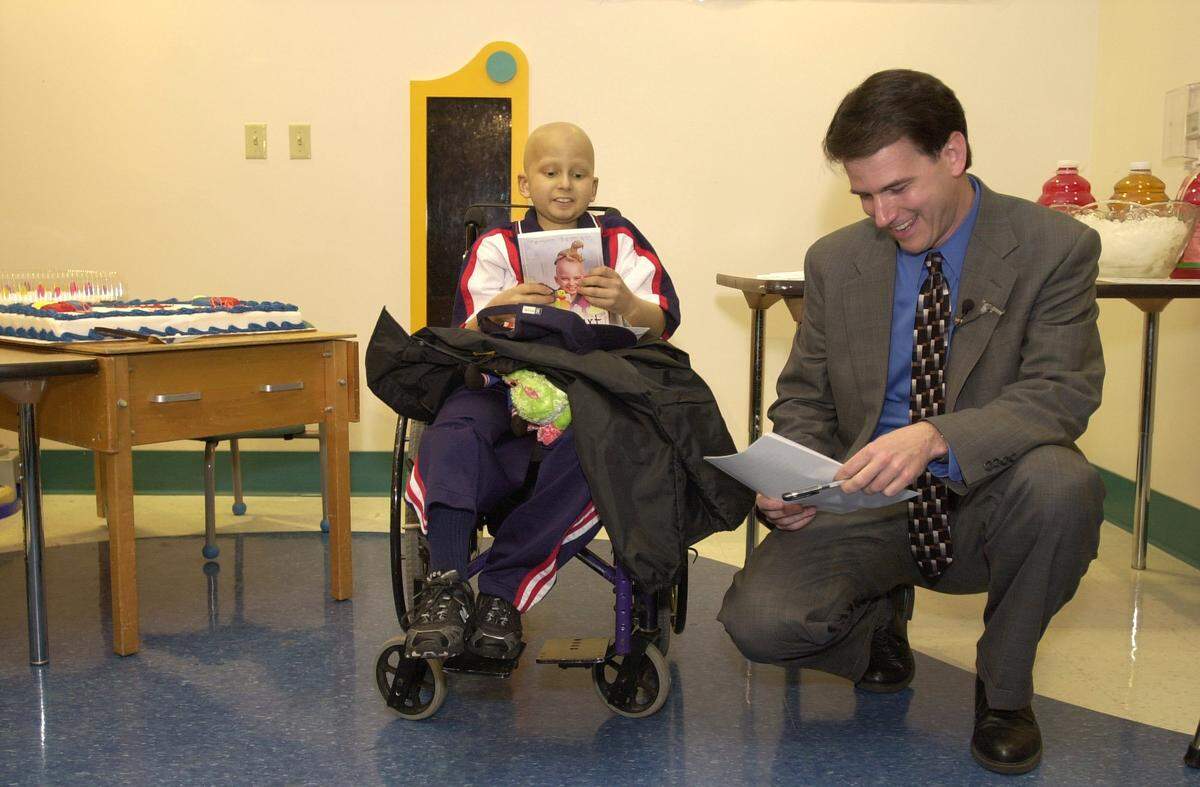 Marvin Bartlett presented Jarrett Mynear a copy of his book “The Joy Cart,” which is about Mynear’s life, at UK Children’s Hospital on March 8, 2002. Jarrett died later that year.