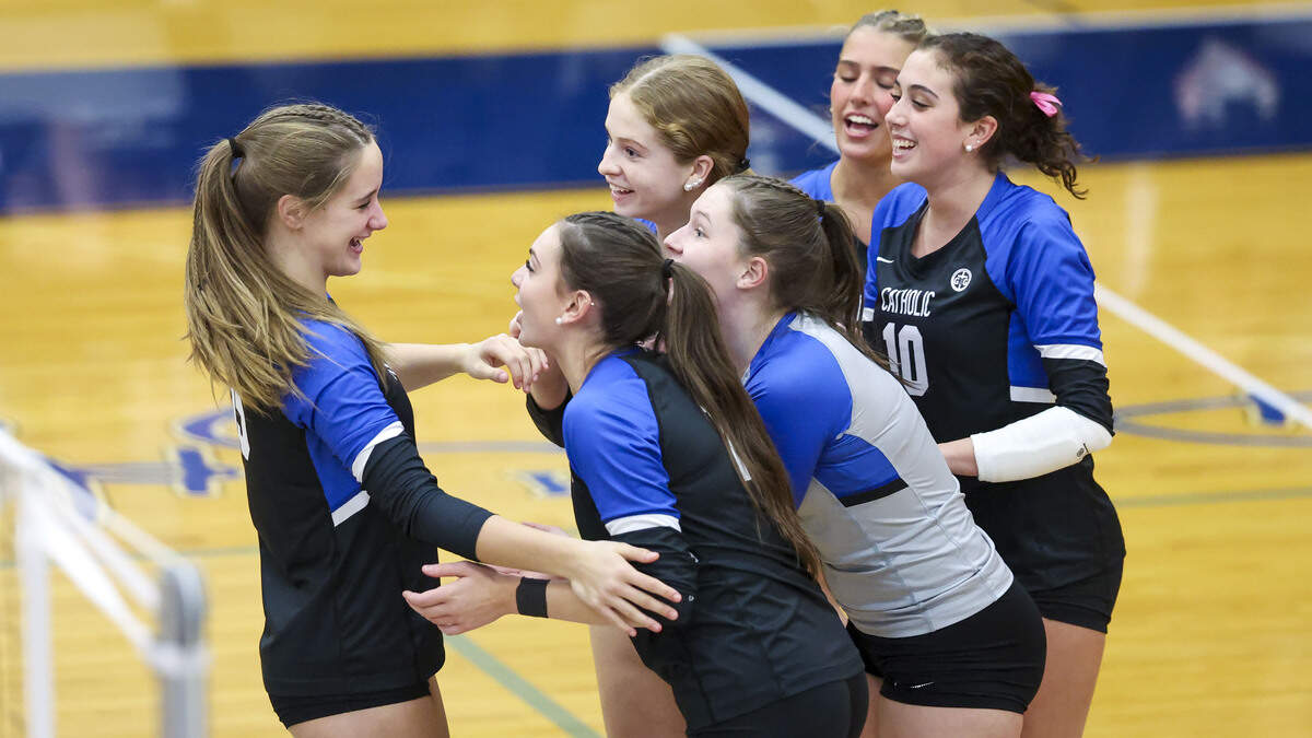 Lexington Catholic's Noah Cecil (15), left, celebrates with teammates during the Knight’s 3-0 win over Scott in the 2025 KHSAA Girls State Volleyball Tournament at Lexington Catholic High School on Monday.