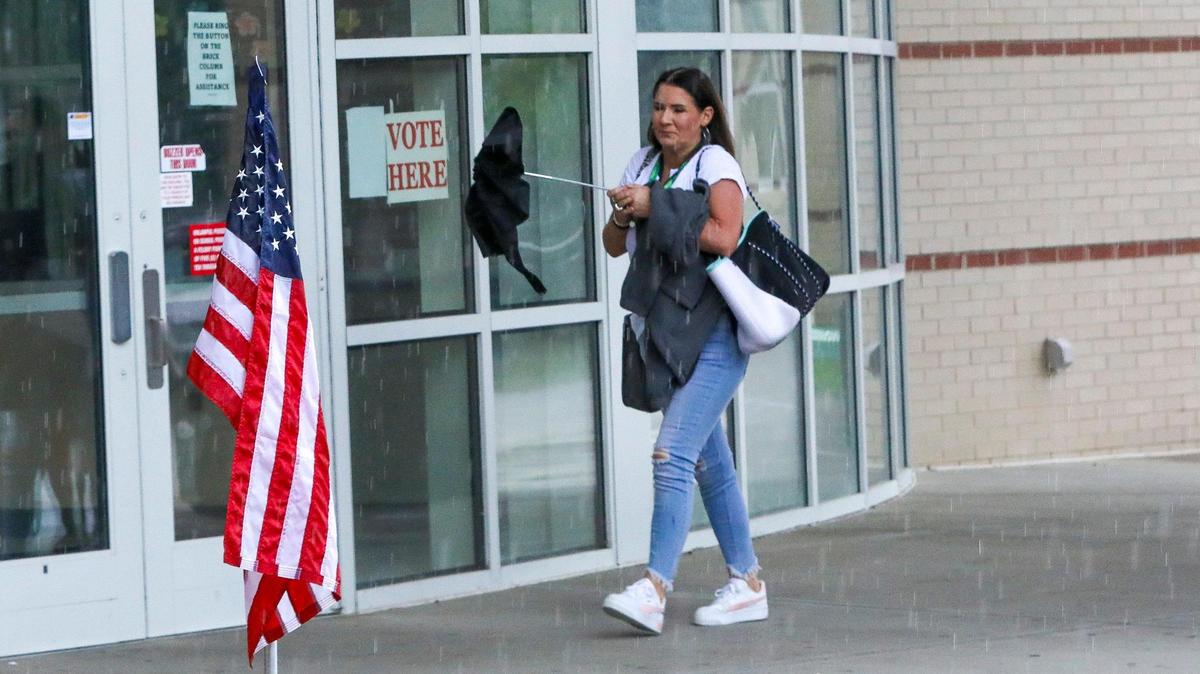 Voters enter under a rainstorm to cast their ballots at Bryan Station High School on May 16, 2023, as Kentucky went to the polls on primary election day. Precinct worker Michael Hale said voting had “been really slow.”