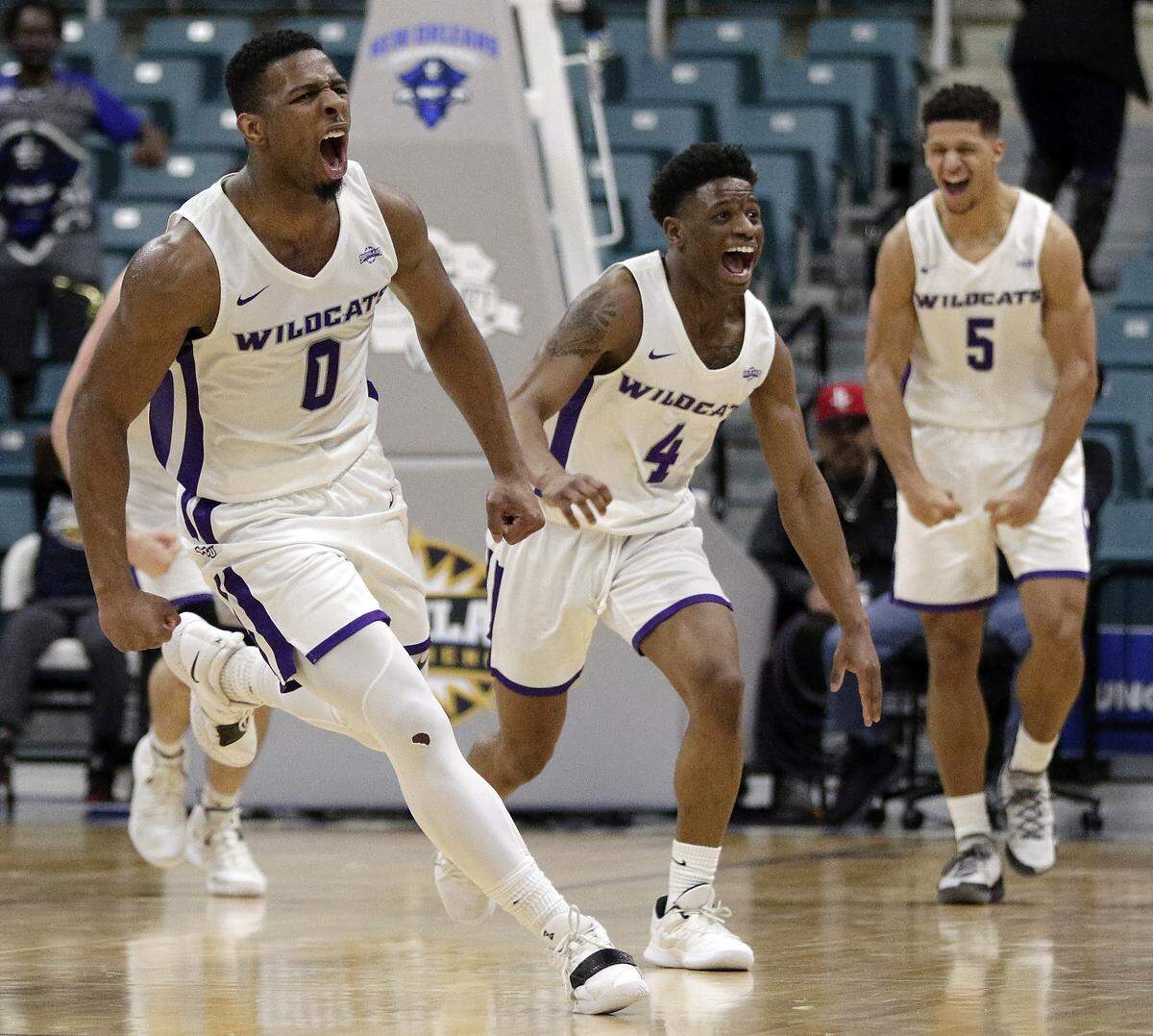 Abilene Christian guards Jaylen Franklin (0), Damien Daniels (4) and Payten Ricks (5) celebrated in the final minute of the Wildcats’ 77-60 win over New Orleans in the Southland Conference Tournament finals.