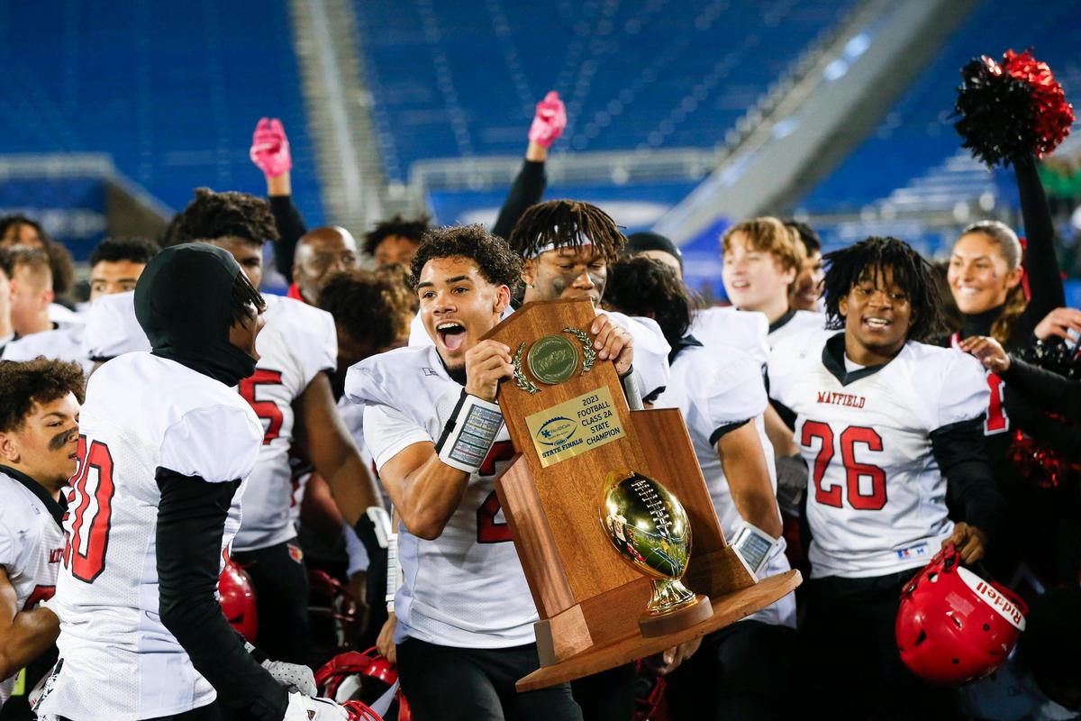 Xavier Biggers celebrates with the Class 2A state championship trophy after Mayfield held off Owensboro Catholic at Kroger Field in Lexington on Friday night. Biggers caught a touchdown pass and returned a kickoff for a TD.