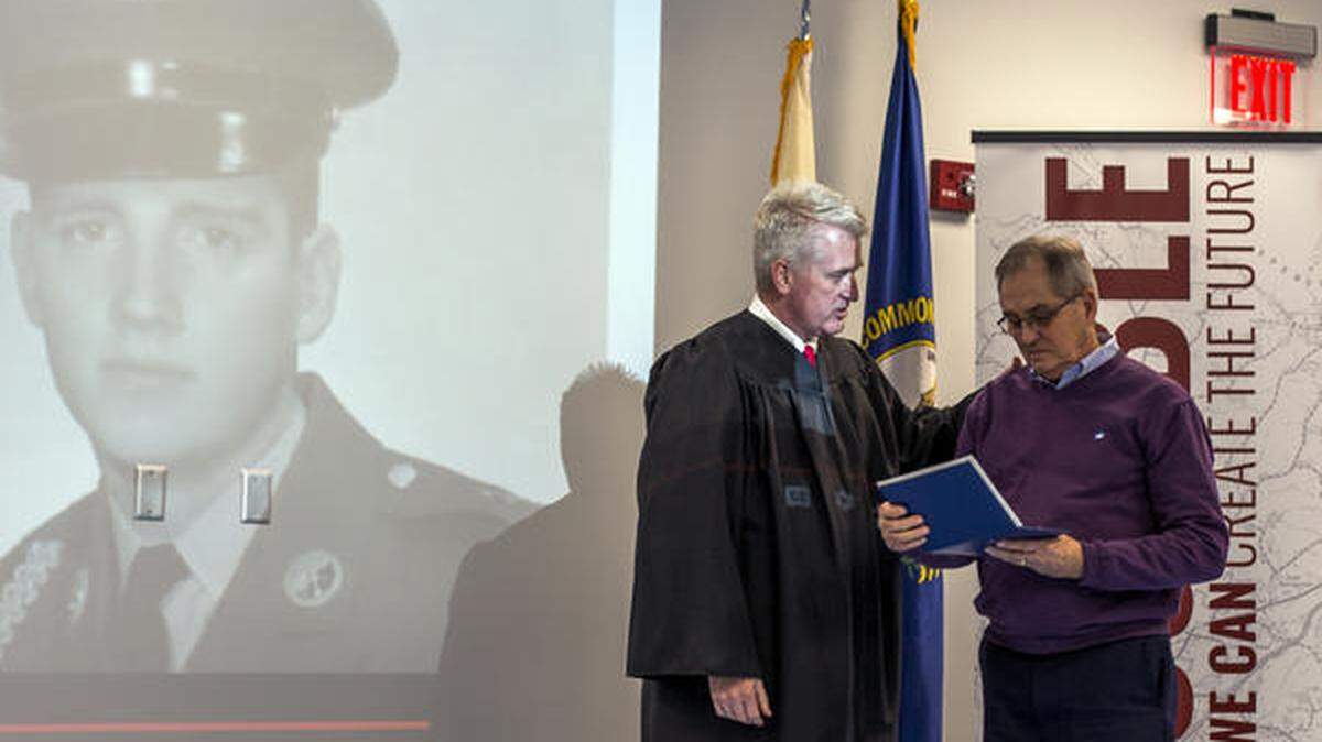 Board Member Damon Jackey presents Edward Gritton with his high school diploma during Tuesday’s Board of Education meeting, Gritton was drafted into the Vietnam War his senior year of high school.
