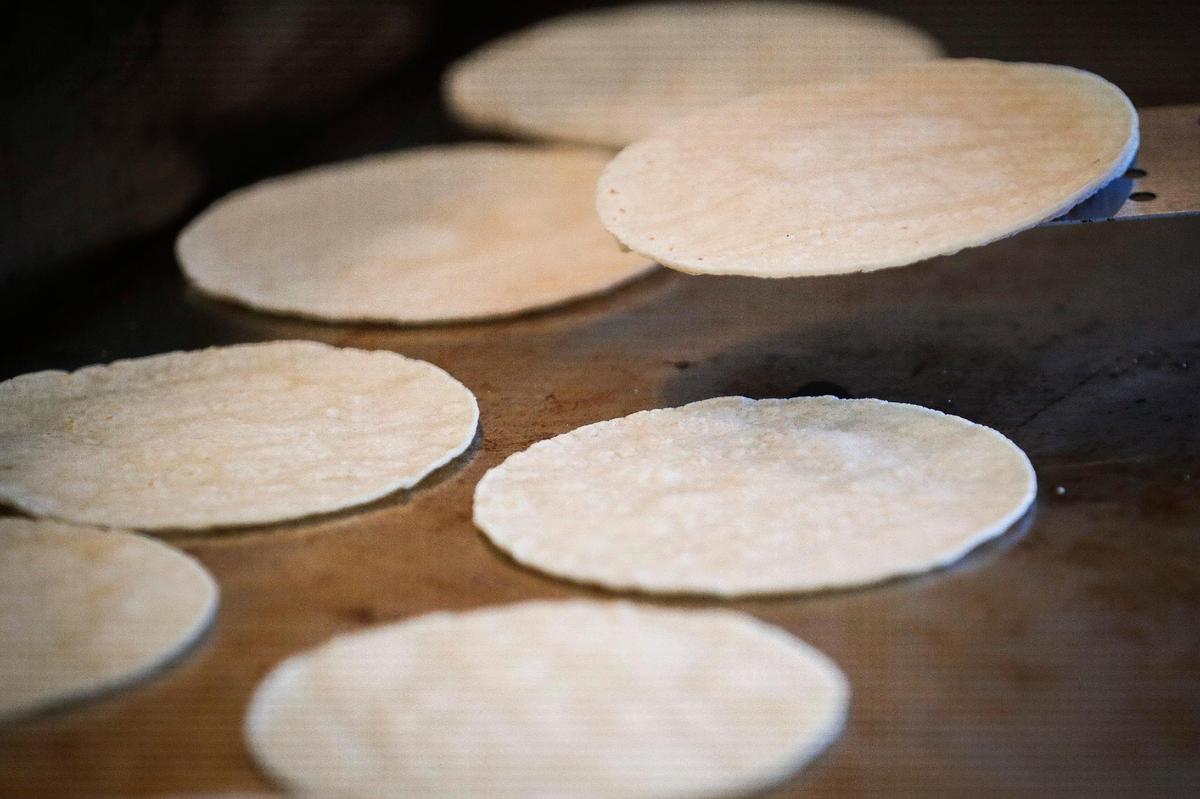 Tortillas are heated on the grill before being packaged as part of a chicken chicken combo at Rosticeria Doña Coco.