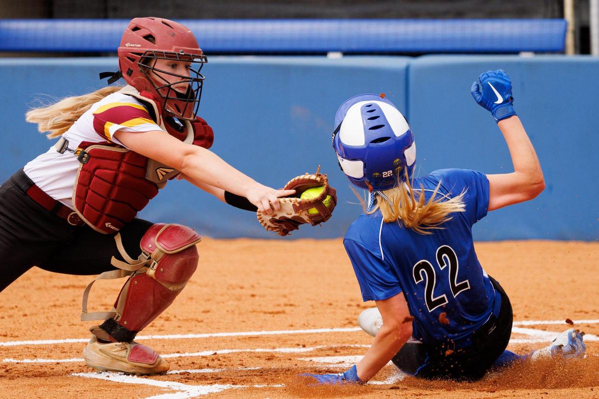 Lexington Catholic’s Lucy Nash (22) slides safely into home to score a run as Harrison County’s Baylee Hudgins, left, tries to make a tag during the state softball quarterfinals on Friday.