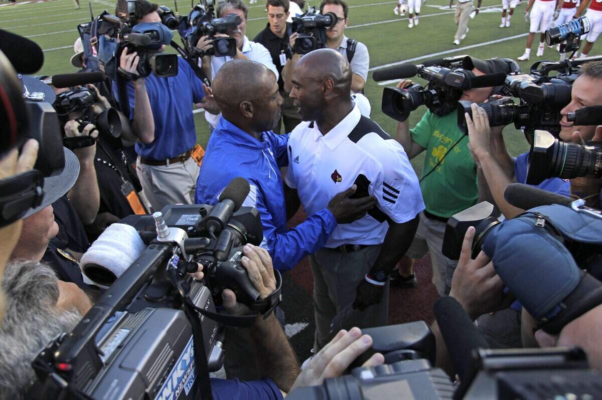 Kentucky Coach Joker Phillips, left, greeted Louisville Coach Charlie Strong after UK beat U of L 23-16 in the 2010 season opener. It was the first game as head men for both coaches.