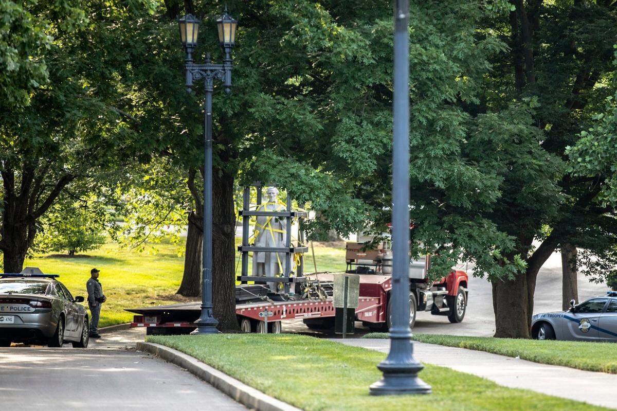 The Jefferson Davis statue is driven away on a trailer after being removed from the Kentucky state Capitol in Frankfort, Ky., on Saturday, June 13, 2020.