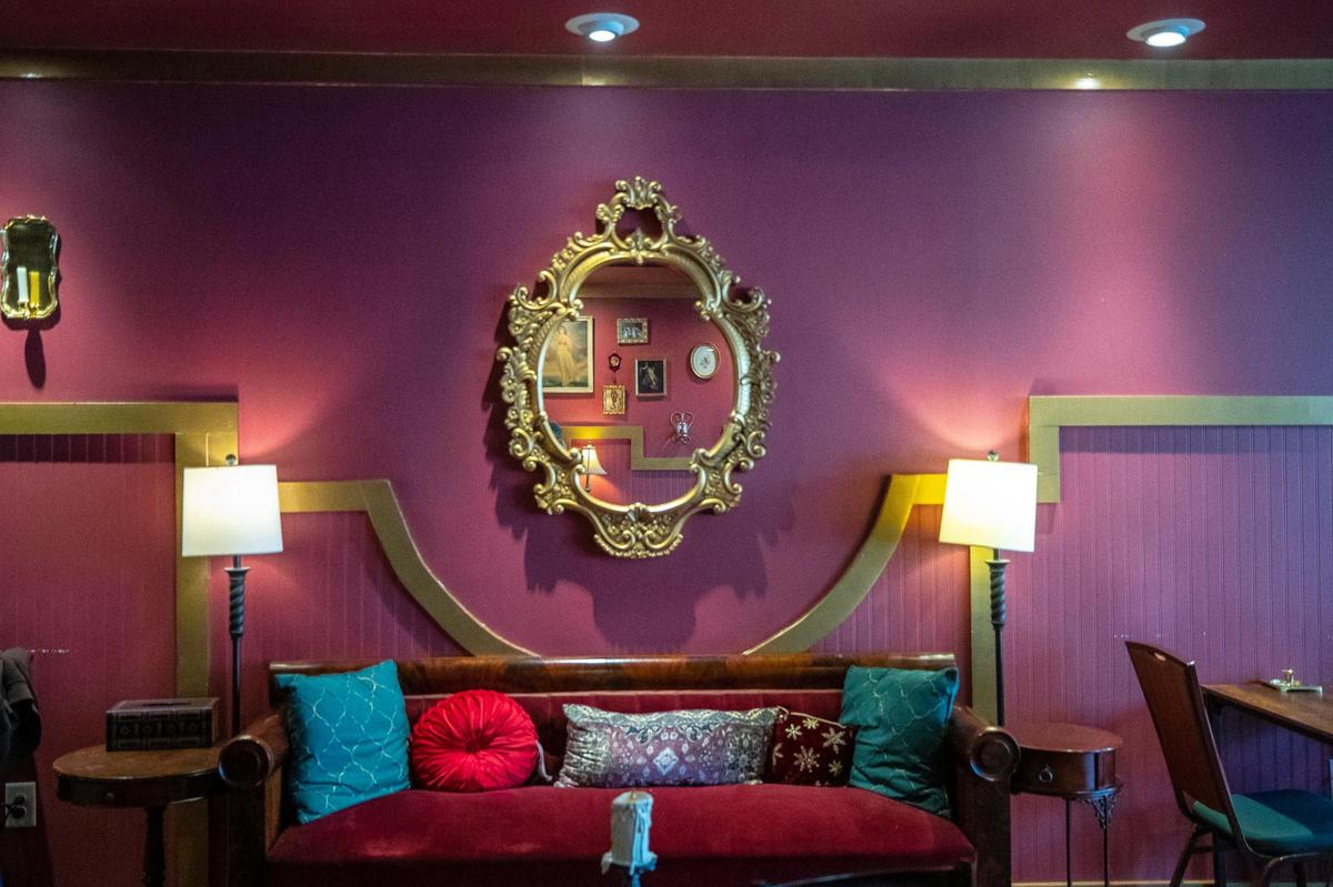 The Creatures’ Cauldron Cafe is tucked behind velvet curtains with burgundy and gold walls, a fireplace and candles.