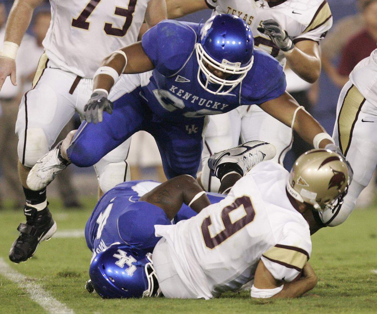 Kentucky’s Austin Moss, bottom, sacked Texas State quarterback Bradley George during a game at UK in 2006.