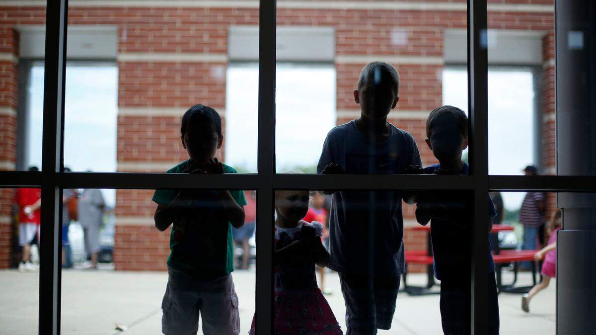Elementary students peek inside of the high school while waiting for Readi Fest to begin at Mercer County High School.