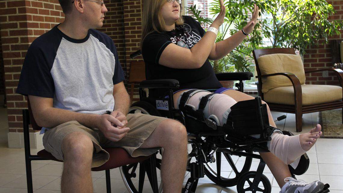 Meghan Roehrich, 12, sitting next to her father, Stephen, held up her hands as she told  reporters how she thought maybe she could stop the car that hit her July 26 in Corbin. The car didn't stop, and police have charged Michael Petery with second-degree assault and leaving the scene of an accident.   