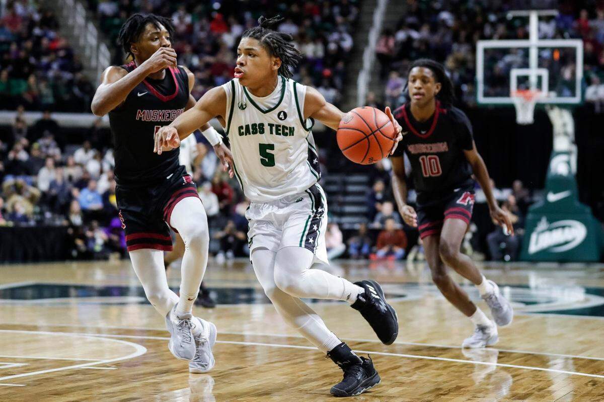 Cass Tech guard Darius Acuff (5) dribbles against Muskegon guard Anthony Sydnor III (4) during the first half of the MHSAA boys Division 1 final at Breslin Center in East Lansing on Saturday, March 25, 2023.