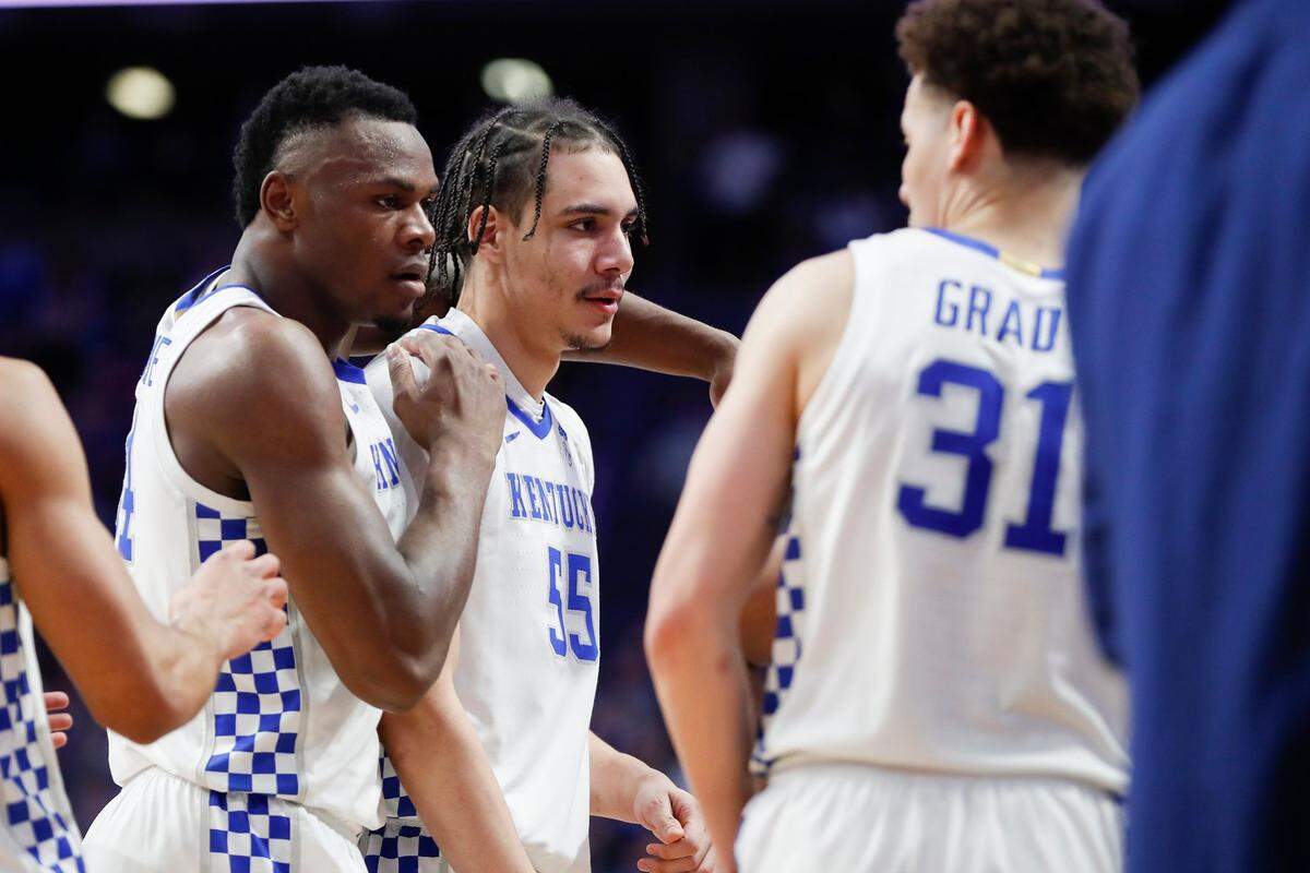 Kentucky’s Oscar Tshiebwe, left, wraps his arm around teammate Lance Ware (55) after a foul was called against Ware during Saturday’s game against Florida.