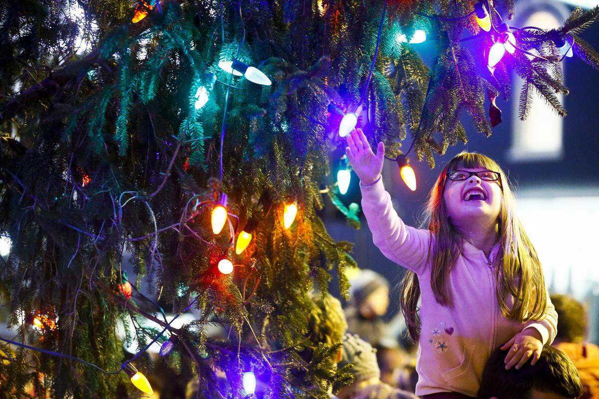 Caelin Thompson, 4, of Lexington, Ky., laughs as she reaches for Christmas lights following the annual tree lighting ceremony during Luminate Lexington at Triangle Park in downtown Lexington, Ky., Friday, Nov. 24, 2017.  This year’s ceremony is Saturday, Nov. 24.