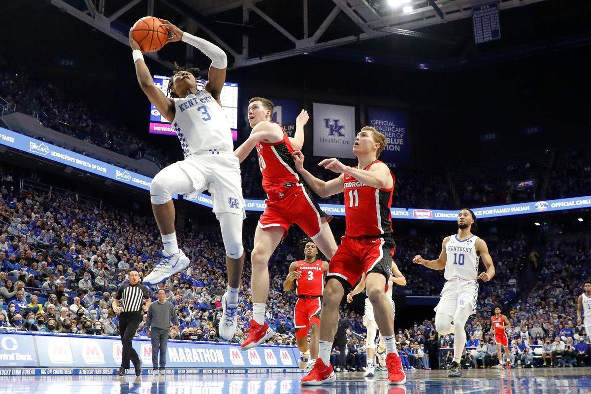 Kentucky Wildcats guard TyTy Washington Jr. (3) shoots past Georgia Bulldogs guard Noah Baumann (20) and Georgia Bulldogs forward Jaxon Etter (11) during a game at Rupp Arena in Lexington, Ky., Saturday, Jan. 8, 2022.