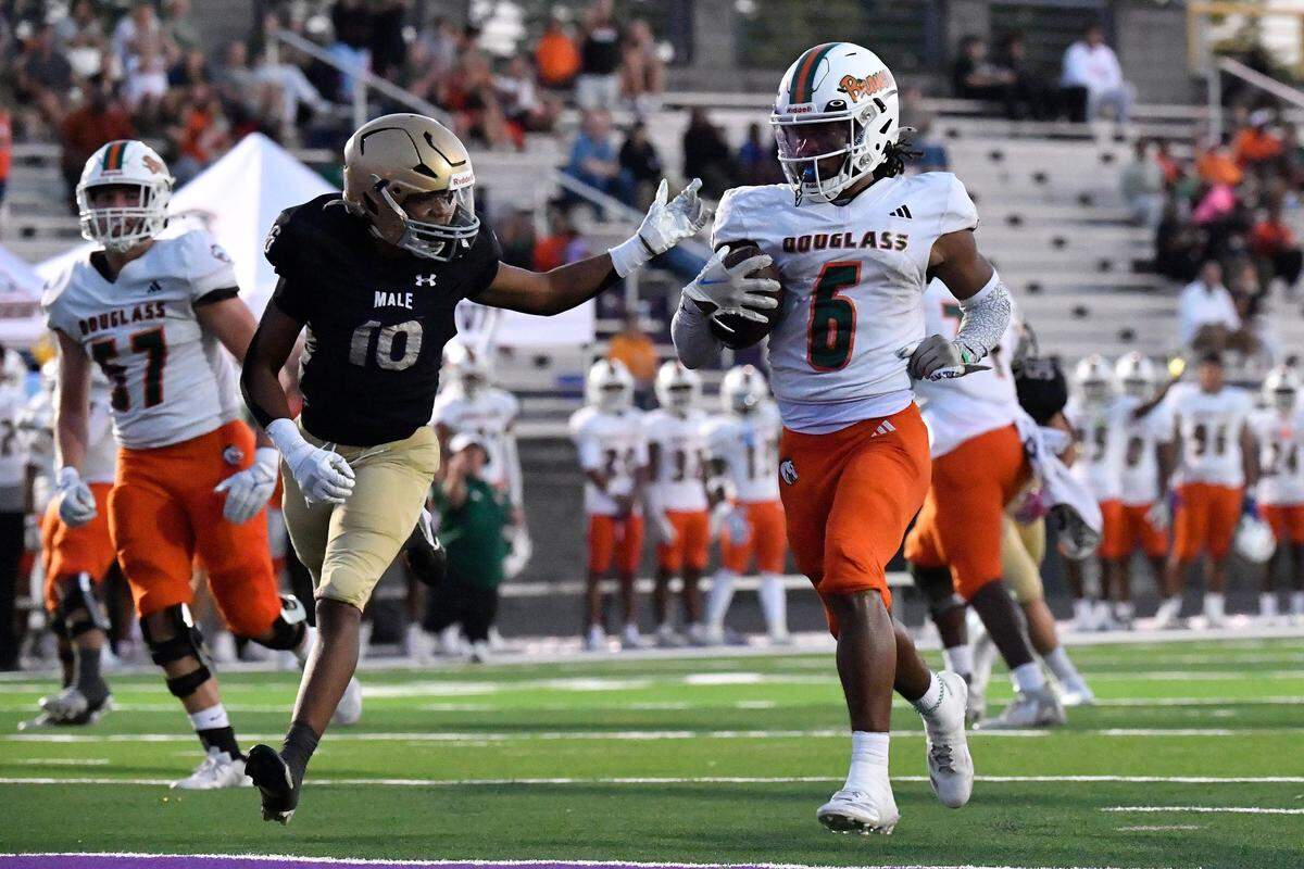 Frederick Douglass' Dakari Talbert (6) crosses the goal line ahead of Male's Tyson Kinsel (10) to score during the first half of their game, Friday, Oct. 3 2025 in Louisville Ky.