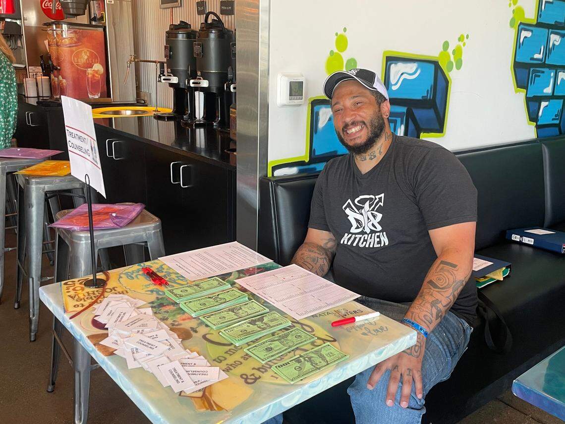 DV8 employee, “PJ,” smiles as he works the “Treatment” table at a reentry event held on Thursday evening.