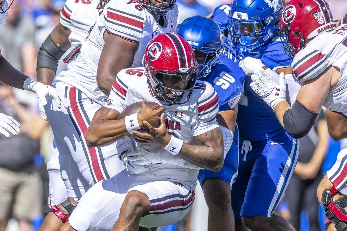 South Carolina quarterback LaNorris Sellers was wrapped up by Kentucky defensive lineman Tre'vonn Rybka (90) during a game at Kroger Field on Sept. 7, 2024. 