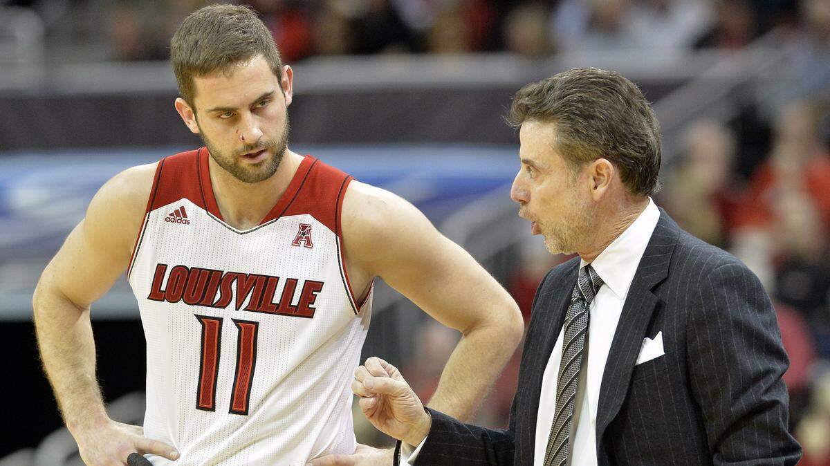 Former Louisville head coach Rick Pitino, right, talked with Luke Hancock during a 2014 game. Hancock and former teammate Tim Henderson will be part of a lawsuit against the NCAA over its sanctions against the team.